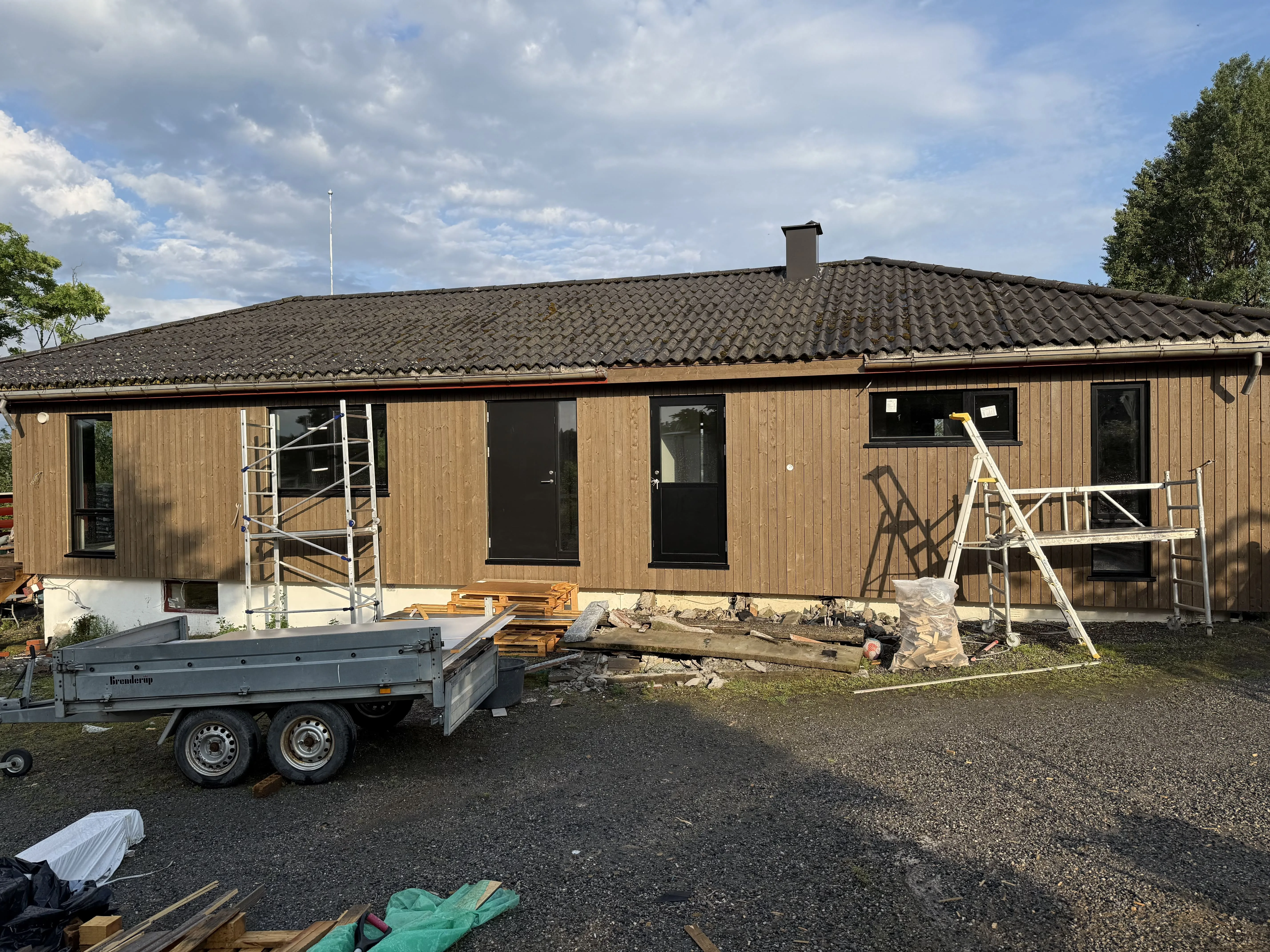 Trekkledt hus under renovering med stillaser