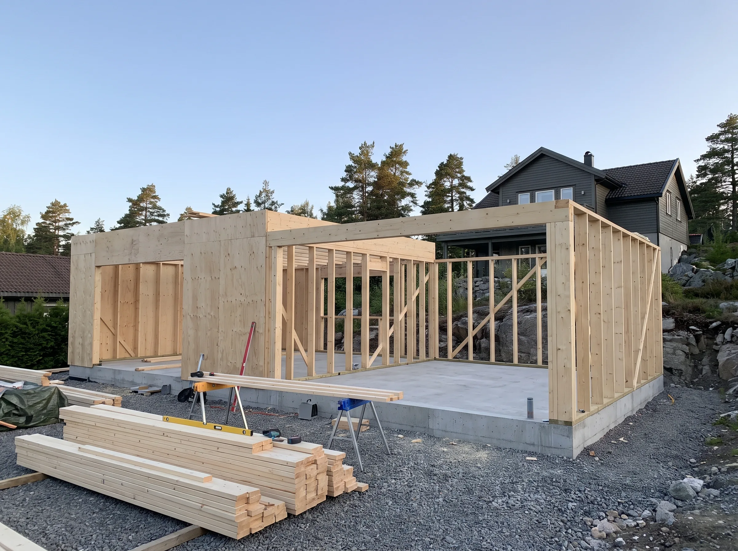 På bildet vises et råbygg i treverk under oppføring, med fokus på bygningskonstruksjoner og fundament