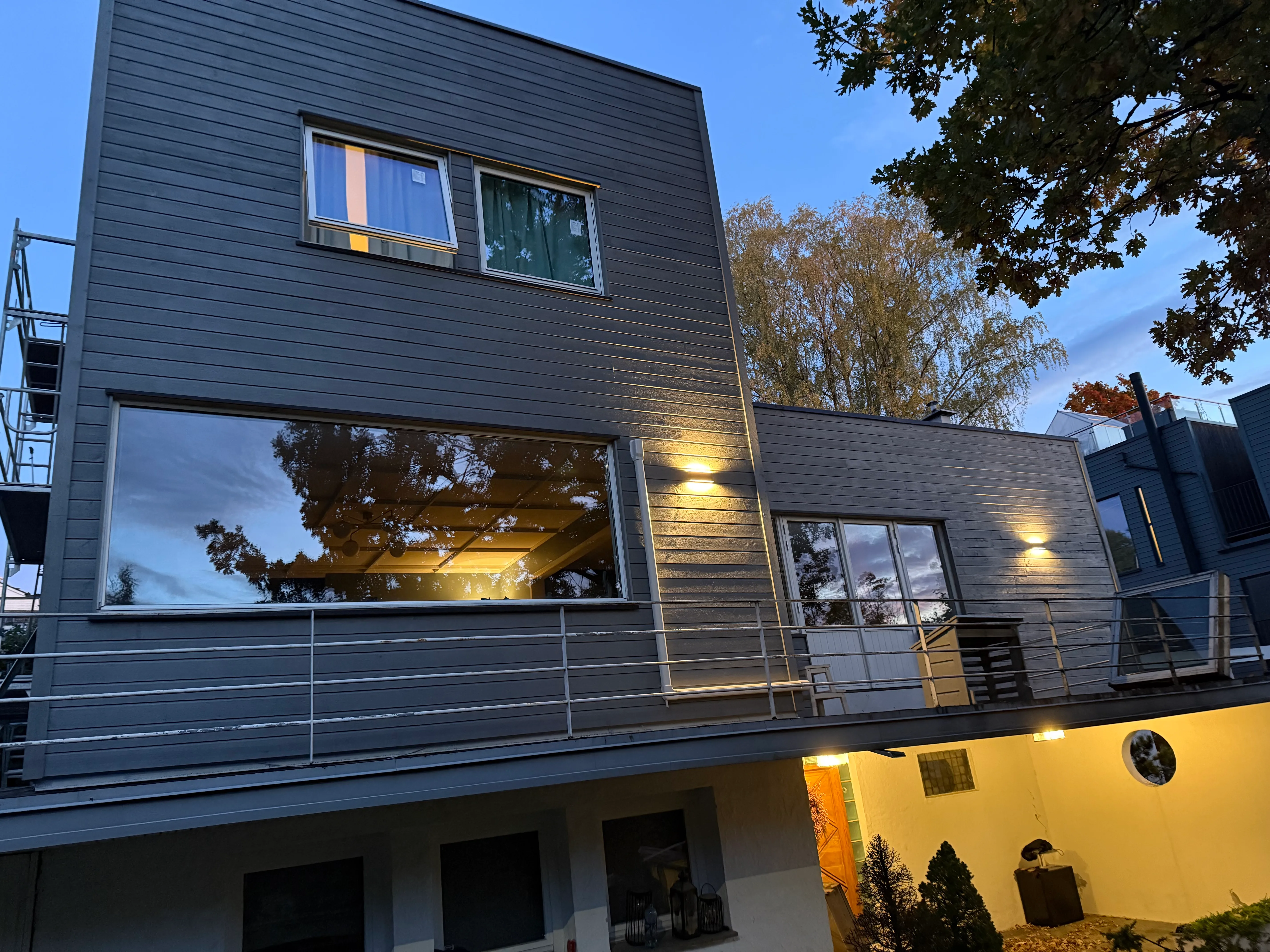 Fasadearbeid på moderne bolig med store vinduer og balkong