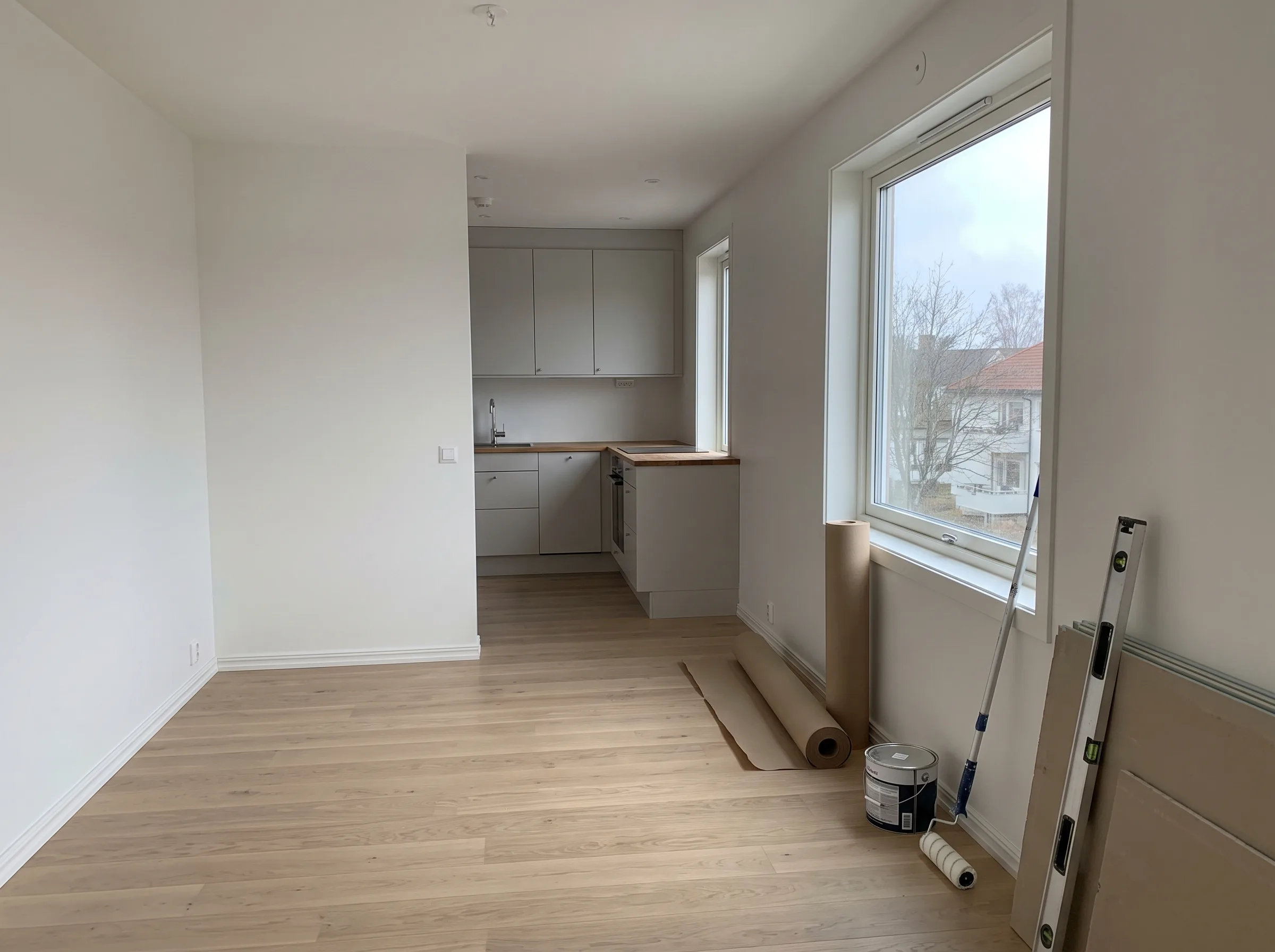 Nyoppusset stue med moderne kjøkken og store vinduer