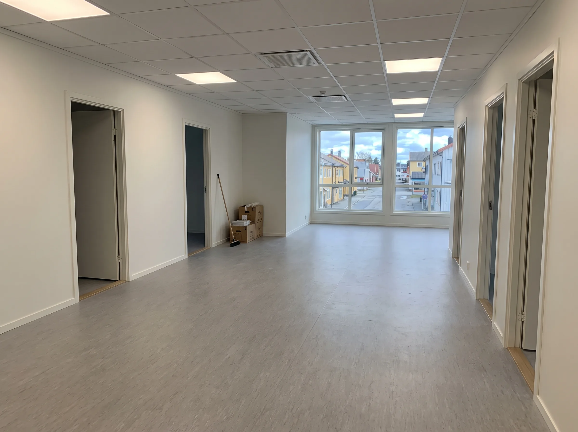 Innvendig oppussing av moderne kontorlokaler med lyse vegger og store vinduer