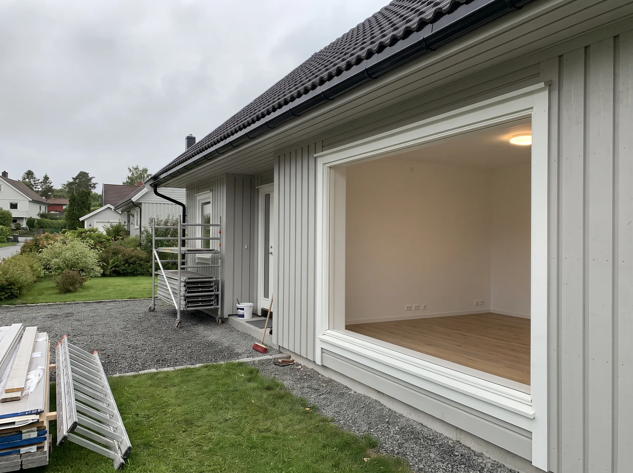 Del av husrenovering med åpning til stuen og byggeutstyr utenfor